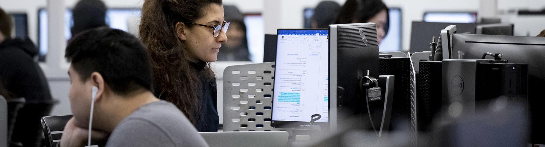 一个坐在技术实验室里盯着电脑屏幕的女人.