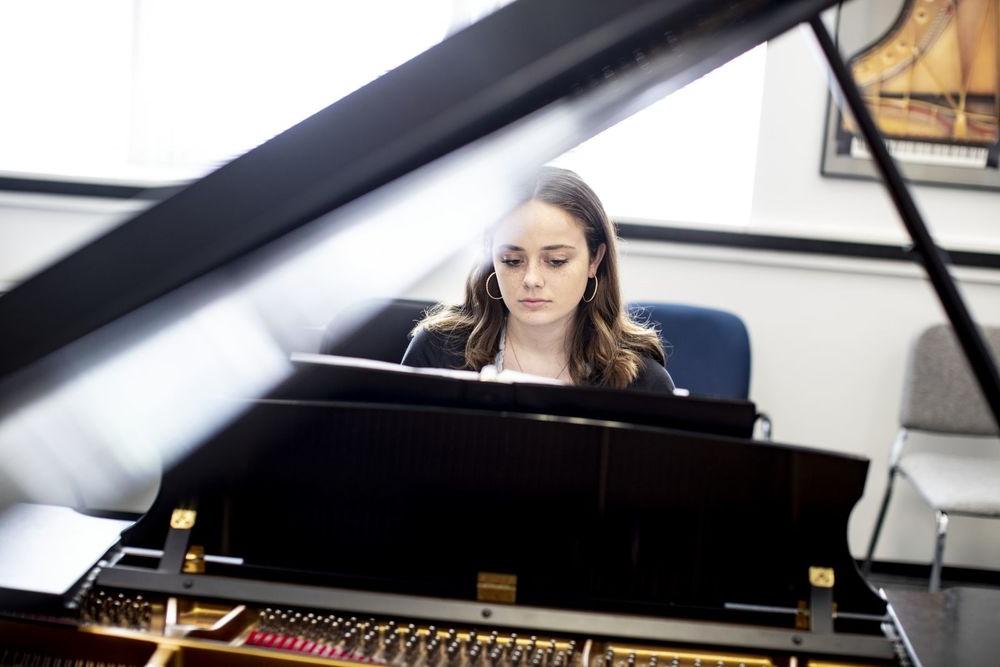 一名博耶音乐舞蹈学院的学生在邓波儿学校的排练室里弹钢琴.